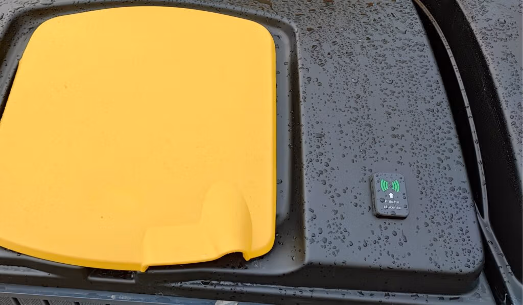 A sensor on a waste bin with a yellow lid.