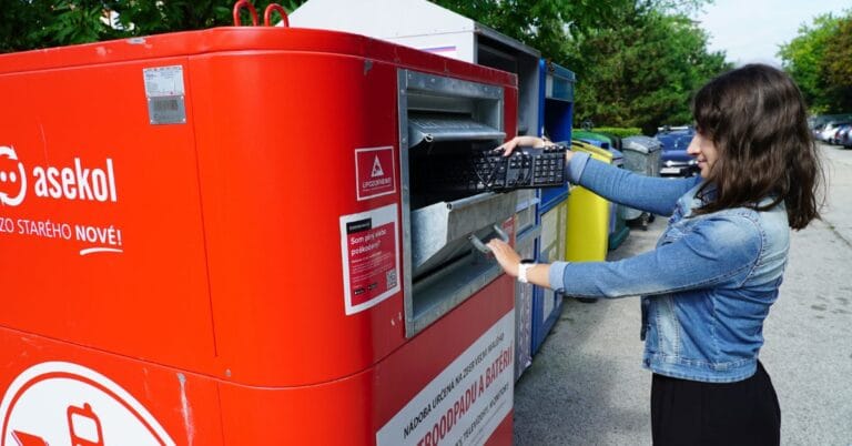 Woman depositing a keyboard into an outdoor electronics recycling container.
