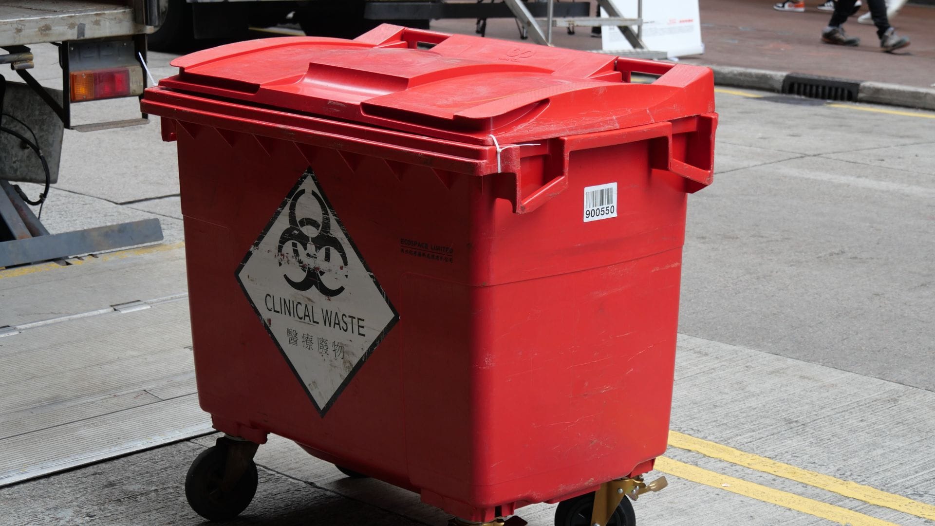 Red clinical-waste bin with biohazard symbol.
