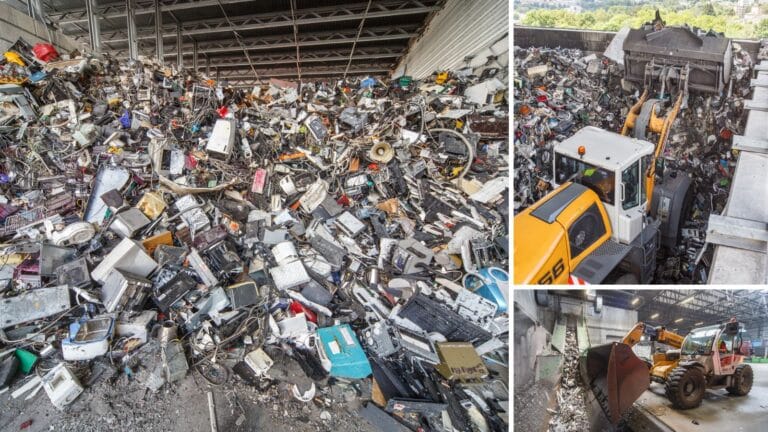Large piles of electronic waste being moved by heavy machinery in a recycling facility.