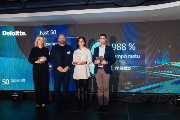 Four people stand stage holding an award for the top 50 fastest growing technological companies.
