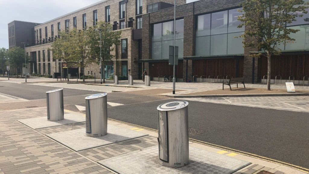 Sleek underground waste bins in a clean, modern streetscape.
