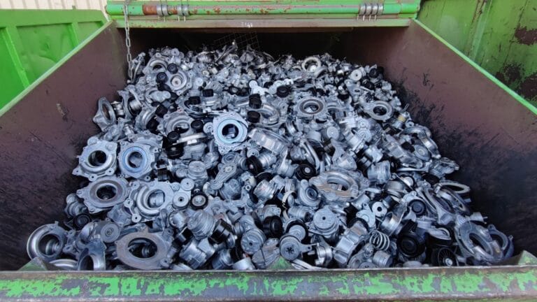 Container filled with discarded metal machine parts and components.