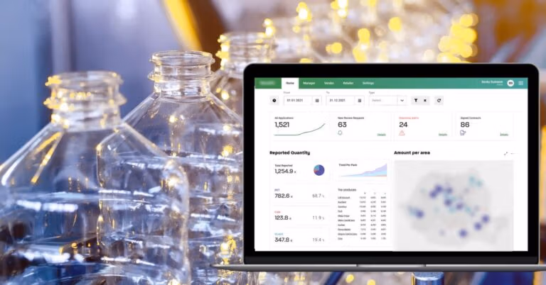 A dashboard on a laptop tracking recycling data, displayed beside empty plastic bottles.
