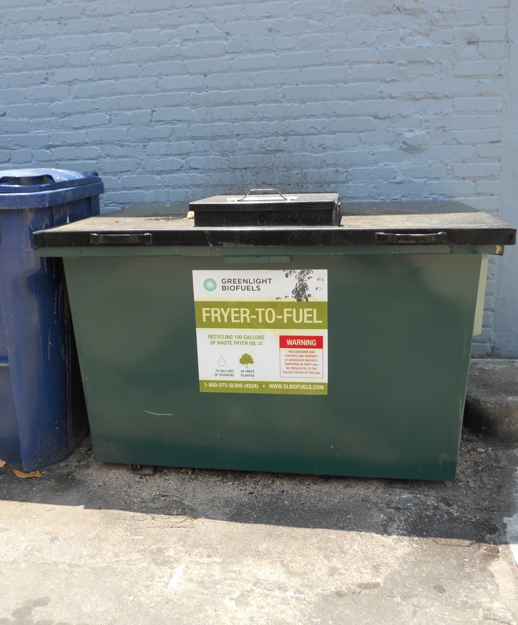 Large outdoor container labeled for used fryer oil recycling.