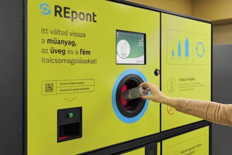 Person inserting a beverage container into an automated deposit-return machine.
