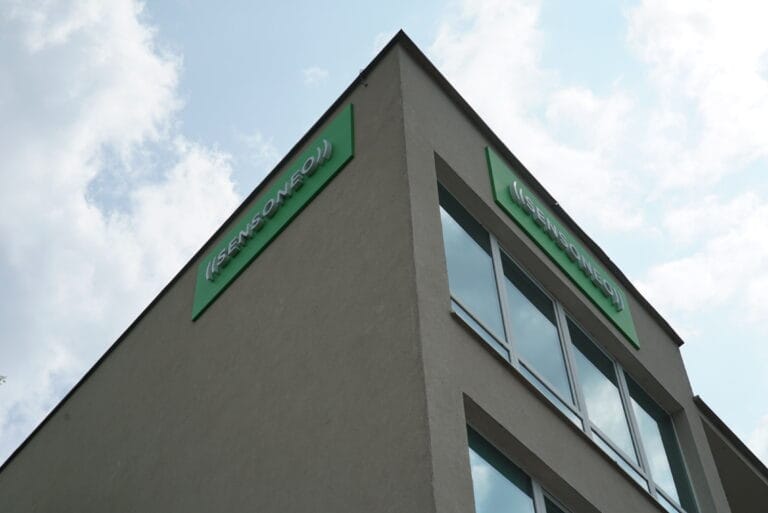 Sensoneo-branded office building viewed from below.