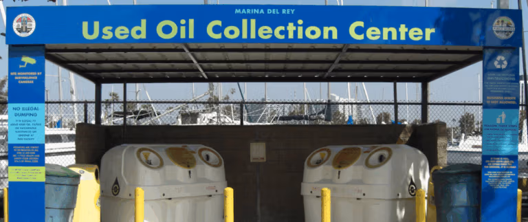 Covered drop-off station with labeled containers for safely recycling used motor oil.