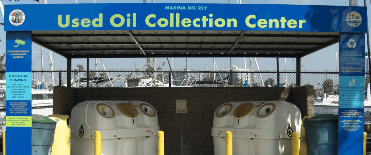 Covered drop-off station with labeled containers for safely recycling used motor oil.