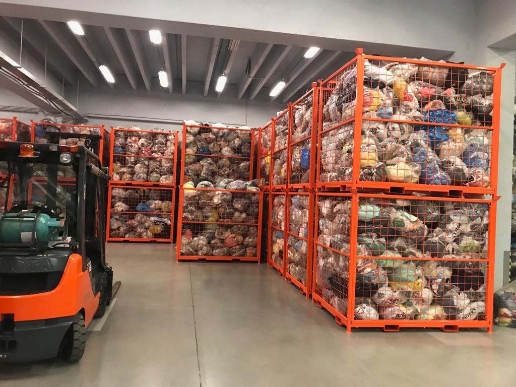 Large orange cages filled with sorted plastic waste, ready for processing.