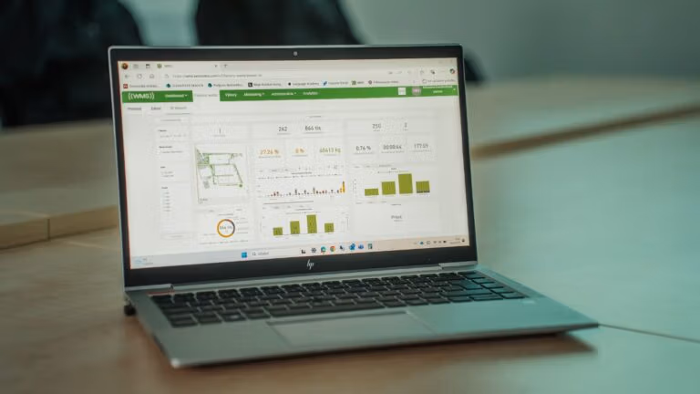 Laptop displaying a waste-management analytics dashboard for monitoring bin status and collection performance
