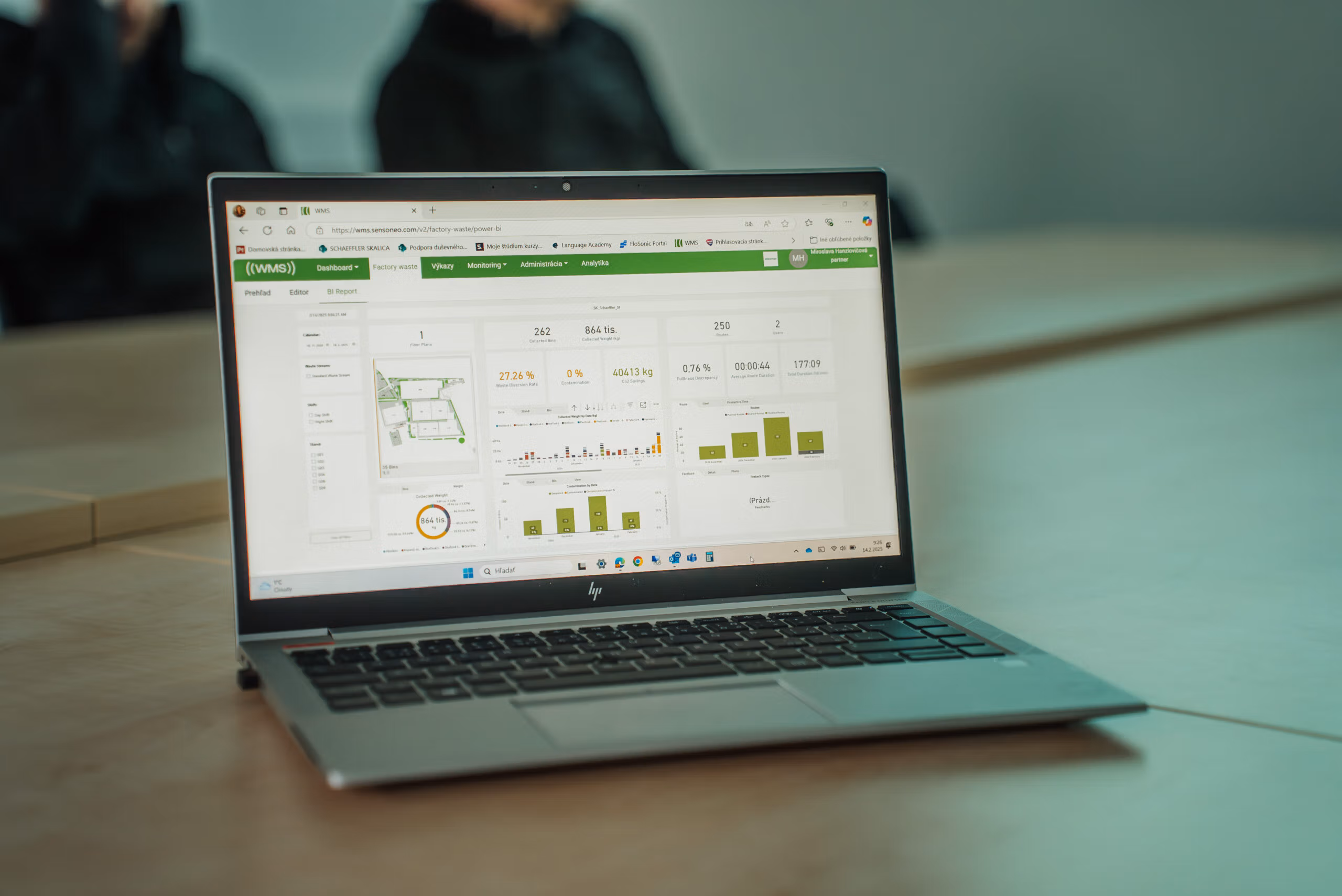 Laptop displaying a waste-management analytics dashboard with charts, metrics, and site overview map.